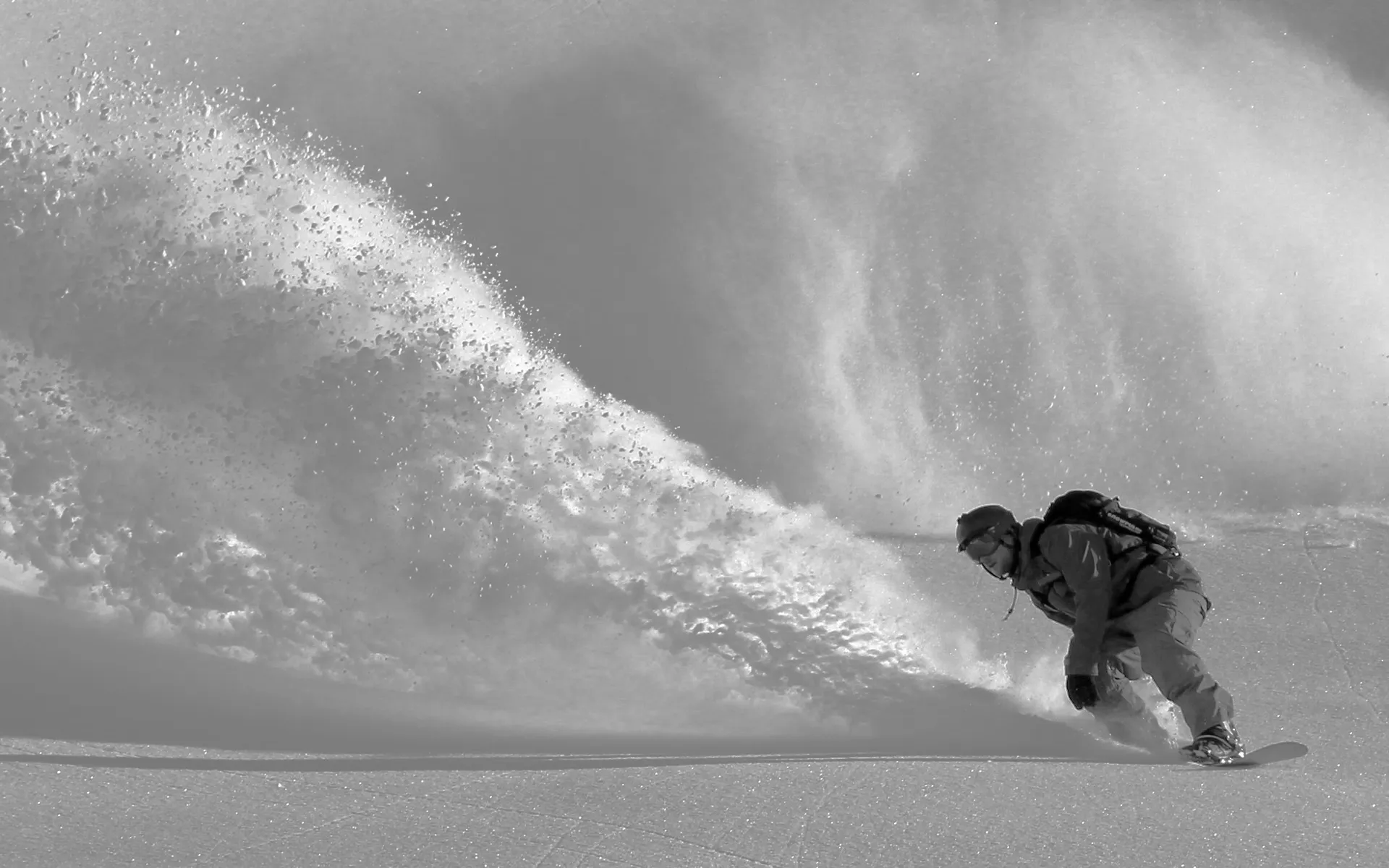 Jody Smithがパウダースノーの雪山を滑りながら雪飛沫をあげている写真