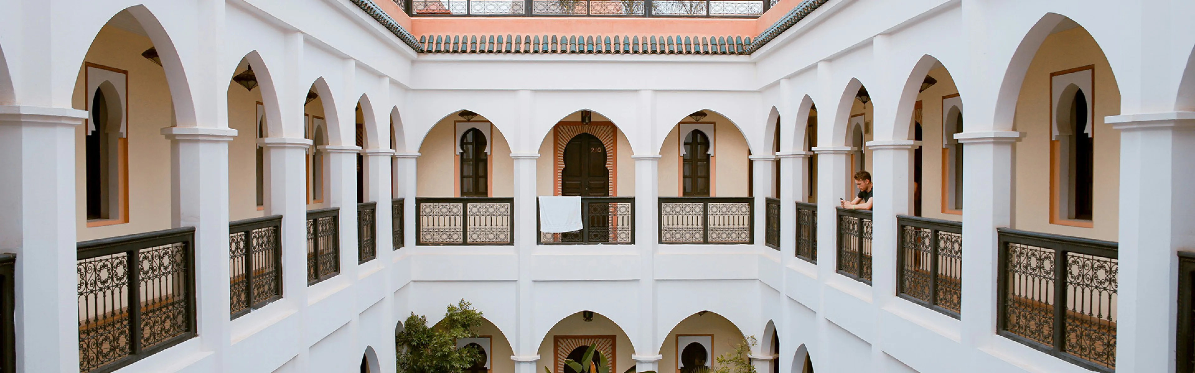 Seaside Terraceのホテル内の写真。廊下から庭のプールと各室の出窓が見えている